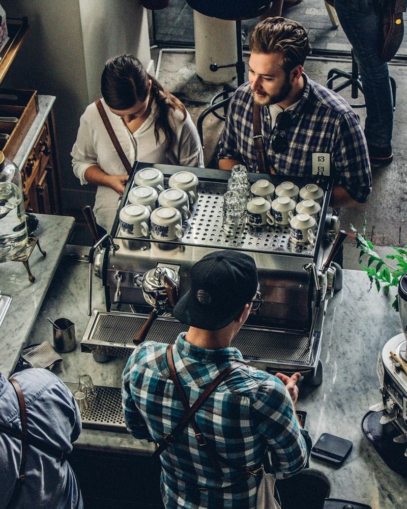 Equipo de una cafetería trabajando en el mostrador