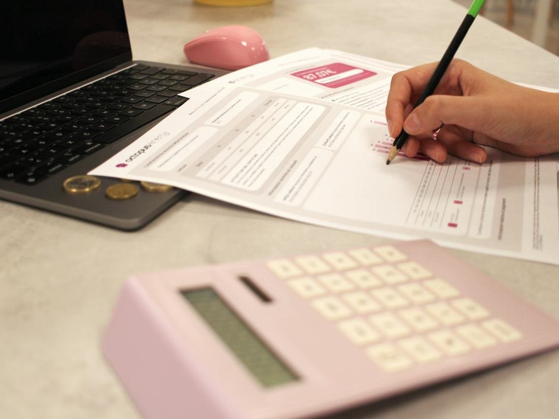 Persona completando un formulario con calculadora